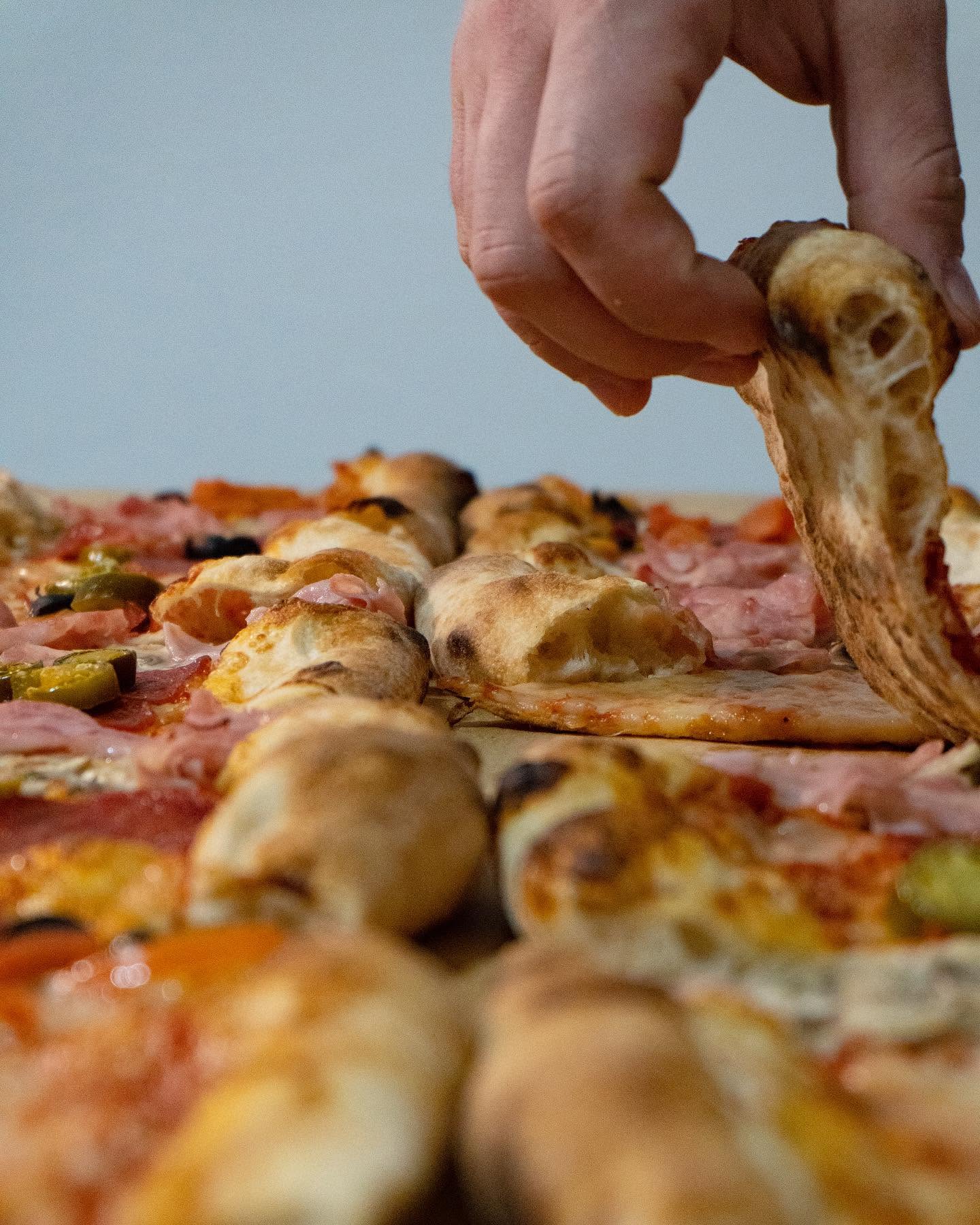 Felie de pizza cu mozzarella întinsă